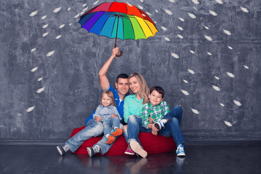 Smiling family in front of animated umbrella and rain 