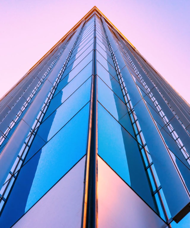Upward view of the side of a skyscraper with lots of windows