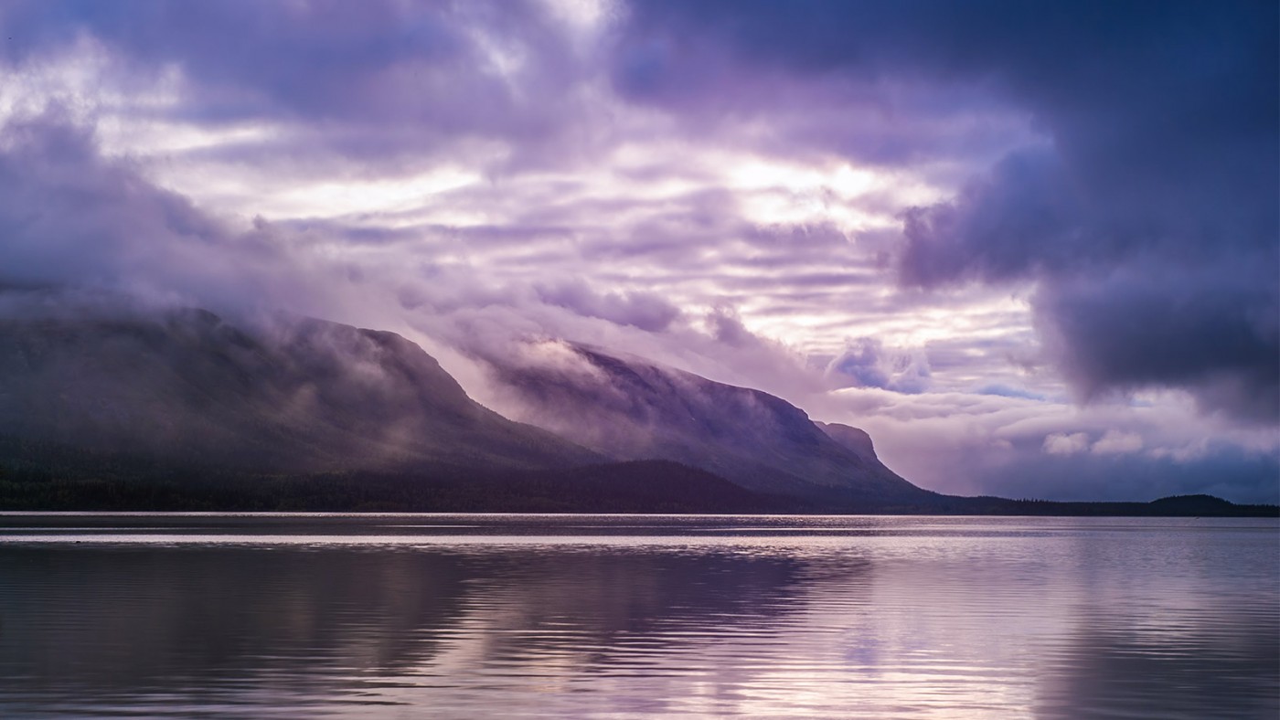 Purple and white clouds in front of distant mountain