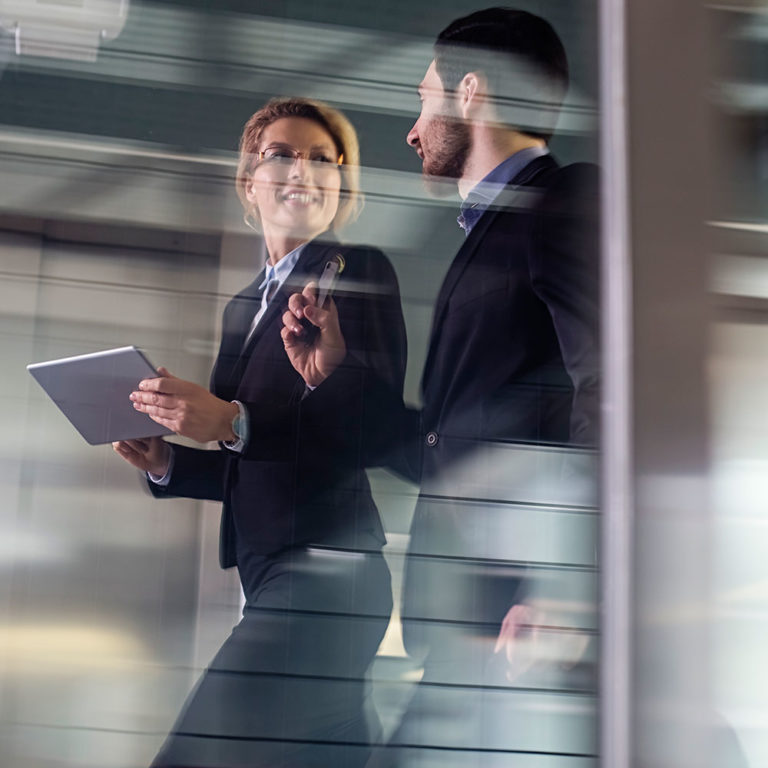 A man and woman in suits walking and talking