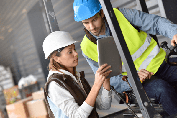 Male and female in vest and hard hat looking at iPad