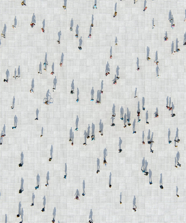 Bird's-eye view of several people spaced out over a large public space