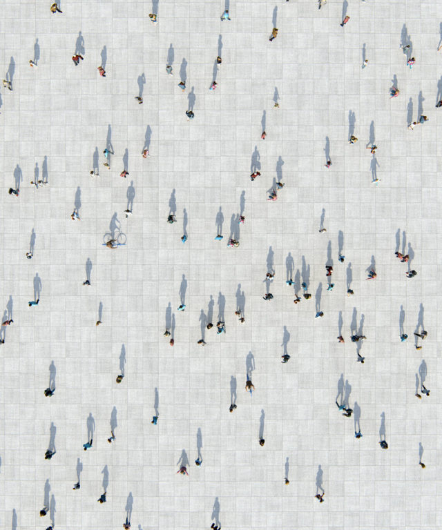 Bird's-eye view of several people spaced out over a large public space