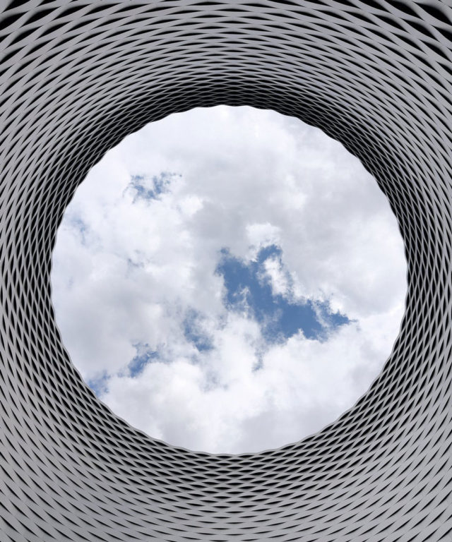 An optical illusion pattern as a circle tunnel with a blue sky at the end