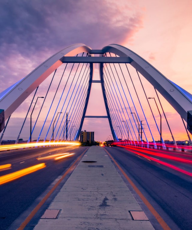 A bridge with two roads and bright blurred car lights on each road