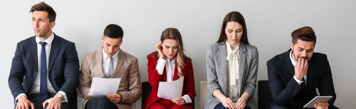 Business people sitting in a hallway preparing for an interview