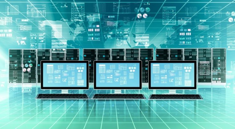 Three computers with several mainframe system in a row behind them