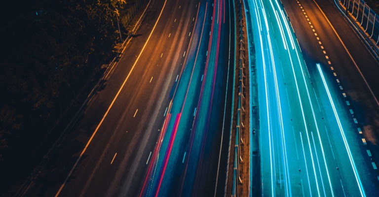 Two roads with bright blue blurred lights on them