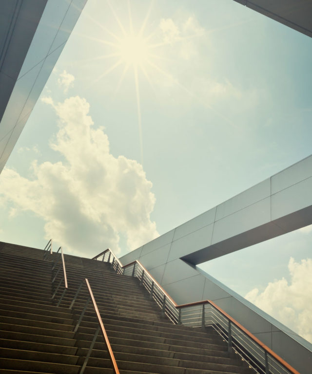 Two stair cases leading up to a blue sky