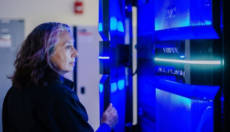 Middle-aged woman opening a mainframe computer