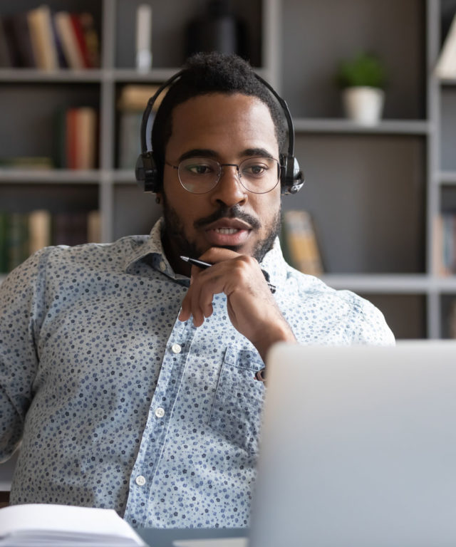 Man with headset working on a laptop