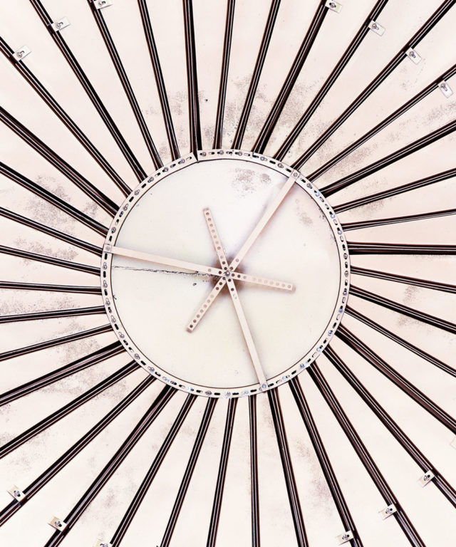A tan structure that has a circle base with many dark wires extended out from the edges of the circle