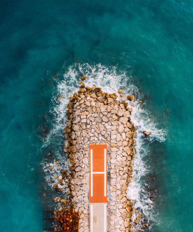 Bird's-eye view of a rocky bank that is protruding into a body of water