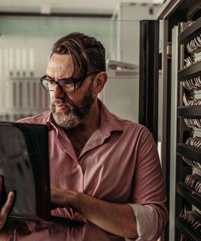 Man working on laptop in server room