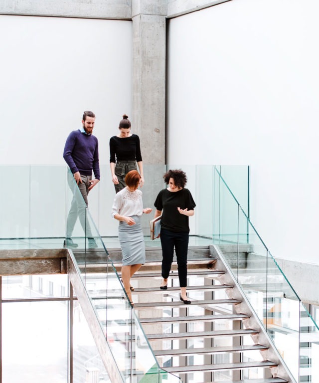Four people walking down stairs while chatting