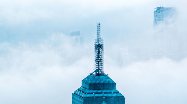 The top of a skyscraper surrounded by fog