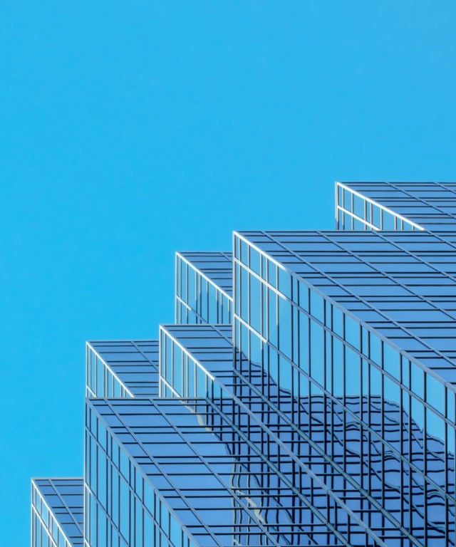 A partial view of the top of a building made of mirrored windows
