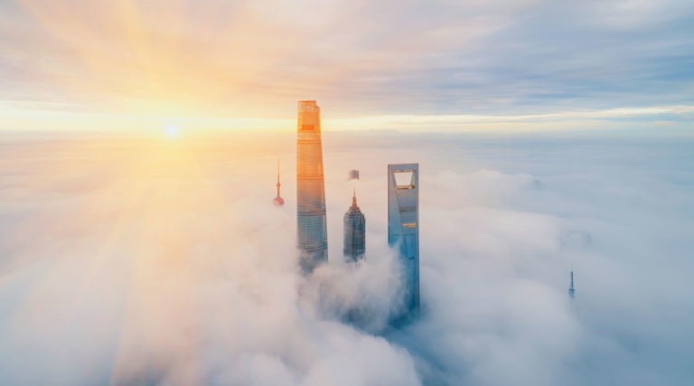 Three tall skyscrapers peeking out over fog