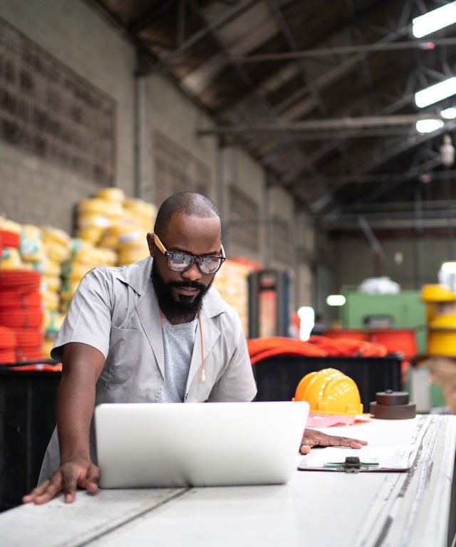 A man in a warehouse working at a workbench