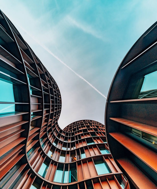 Worm's-eye view up the side of a tall abstract building with many windows