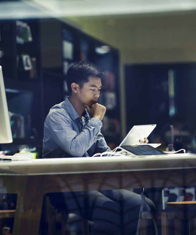 Man working on a tablet in dark office