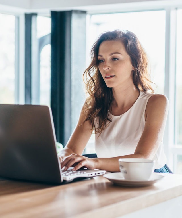 Woman working on a laptop in a coffee shop