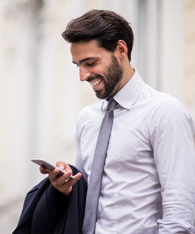 Man in suit smiling at his cell phone