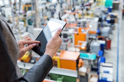 Worker on a tablet in a manufacturing plant