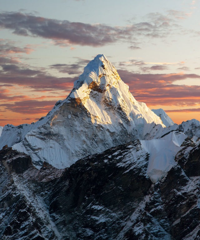 Snowy mountain peak against a sunset