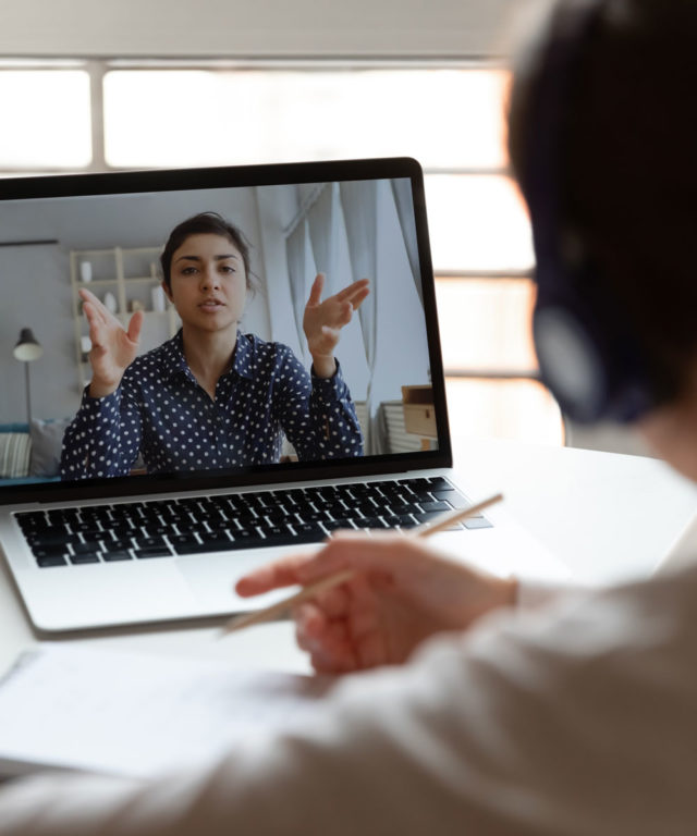 Man video chatting a coworker on his laptop