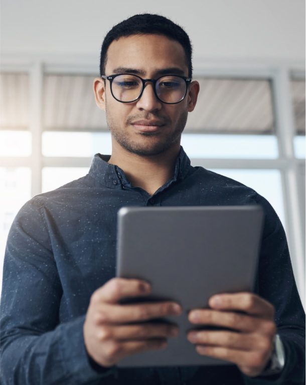 Man wearing glasses using a tablet in the office