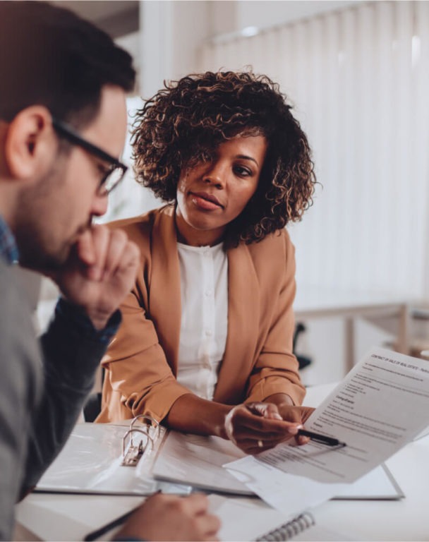 Three coworkers looking at a paper at a conference table