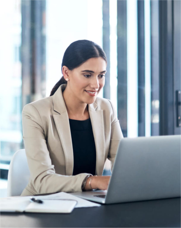 Woman smiling and working at her computer at her desk