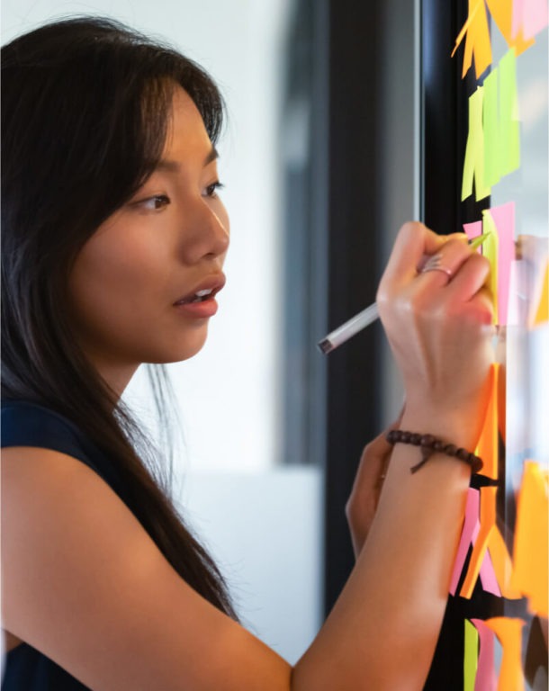 Close-up of woman writing on a whiteboard