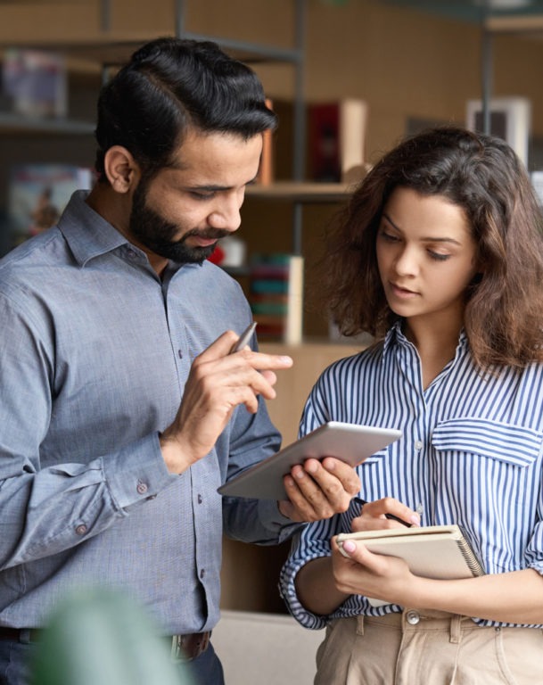 Man holding tablet speaking with female colleague