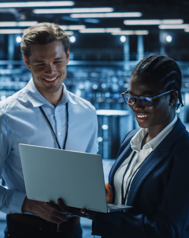 Two coworkers staring at a laptop