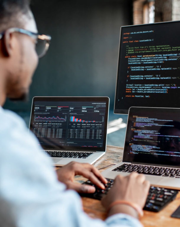 A male working on two computers