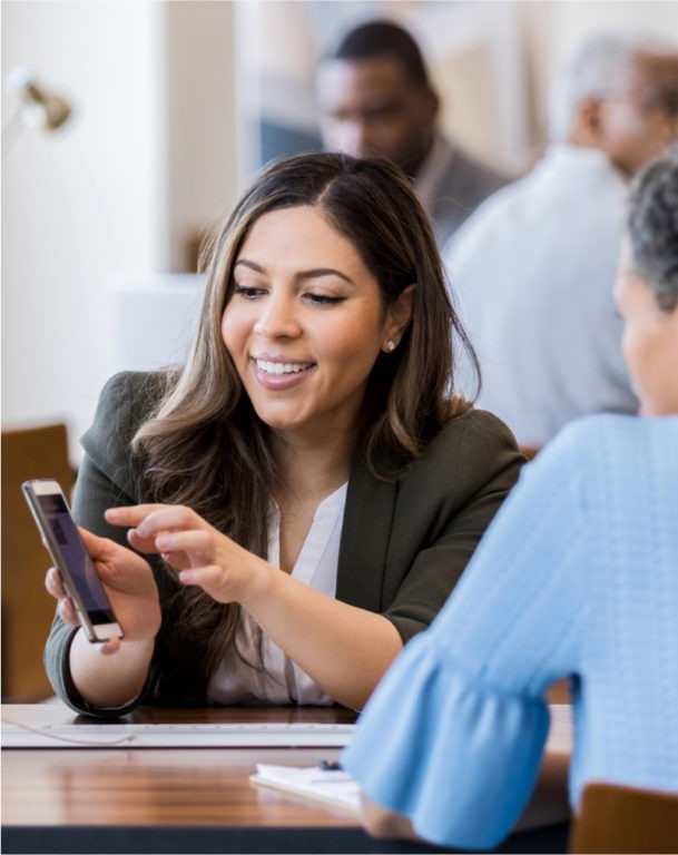 Woman showing her cellphone screen to woman