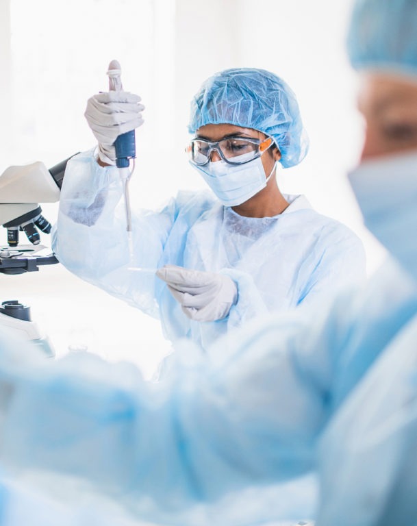 Scientists wearing full protective suits working in laboratory