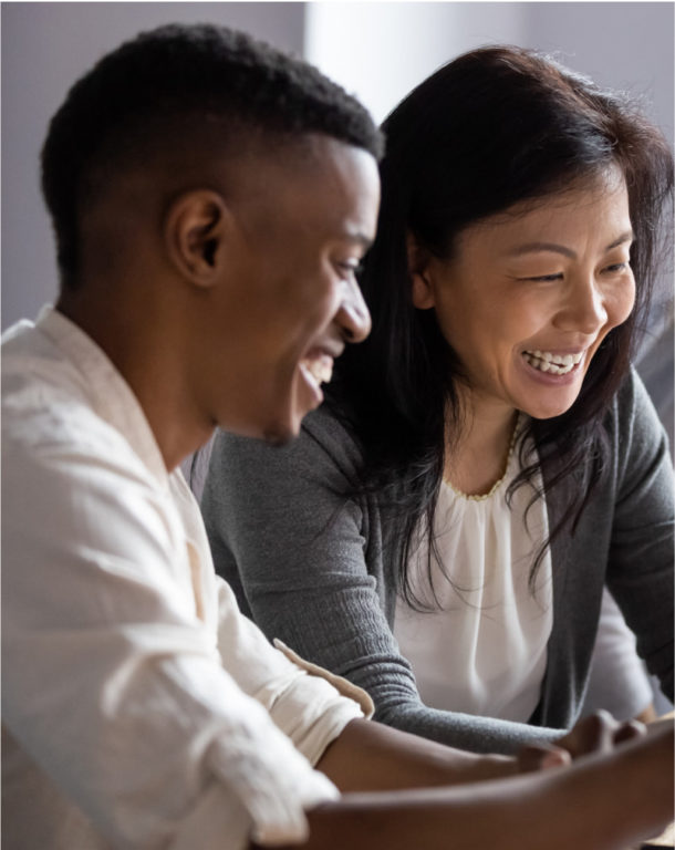 Two people viewing laptop with two colleagues in the background