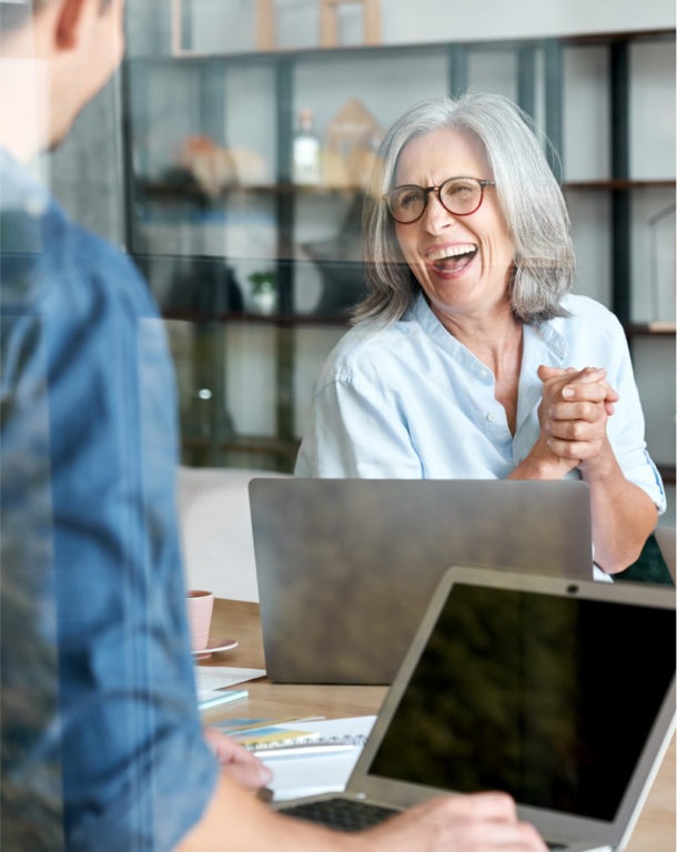 Happy mature woman at group office meeting