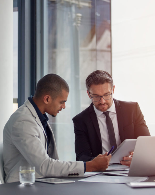Two men working in an office on a laptop
