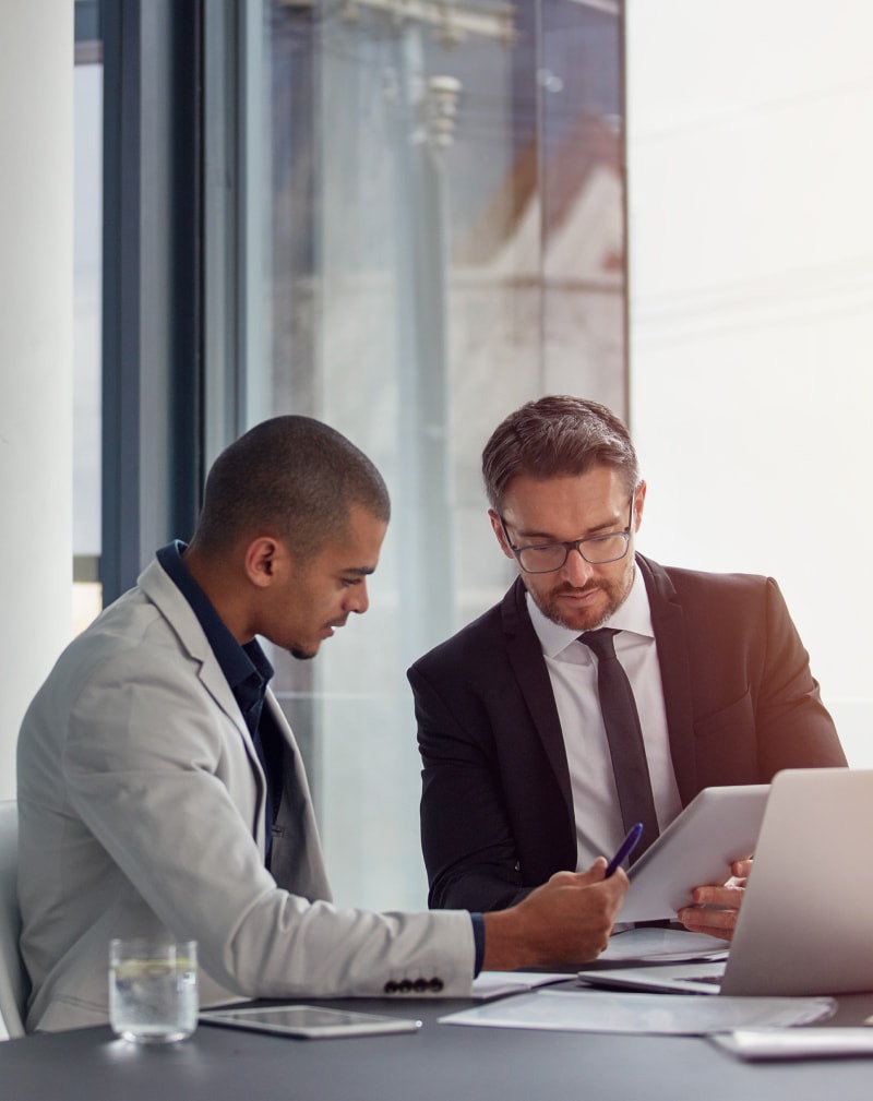 Two men working in an office on a laptop