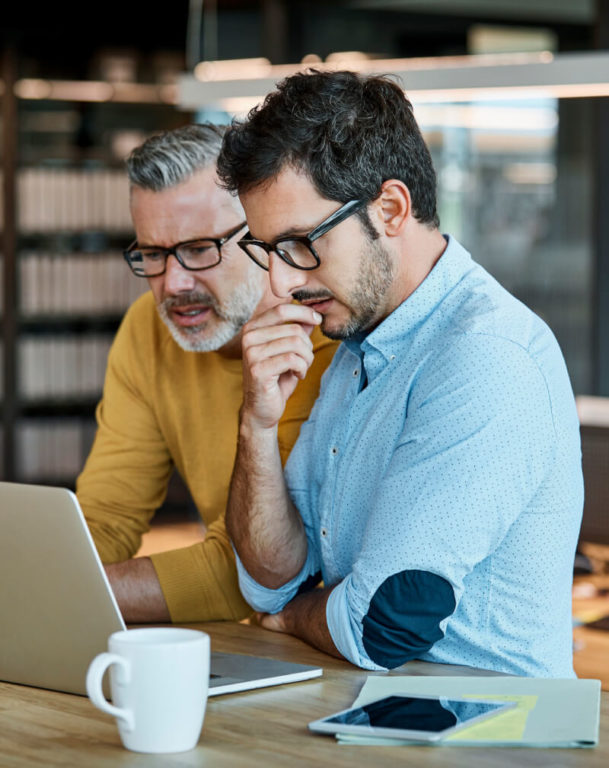 Two businessmen working on a laptop computer