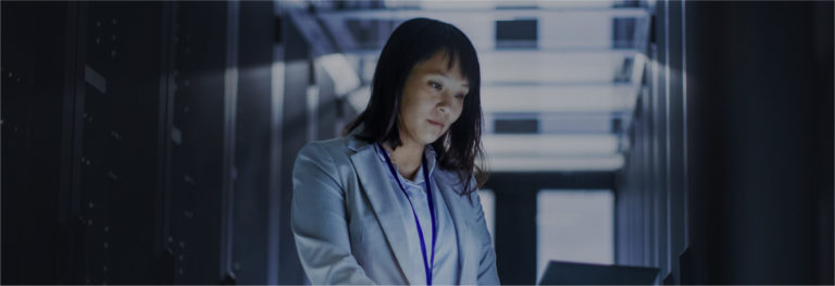 Woman working in a dimly lit data center