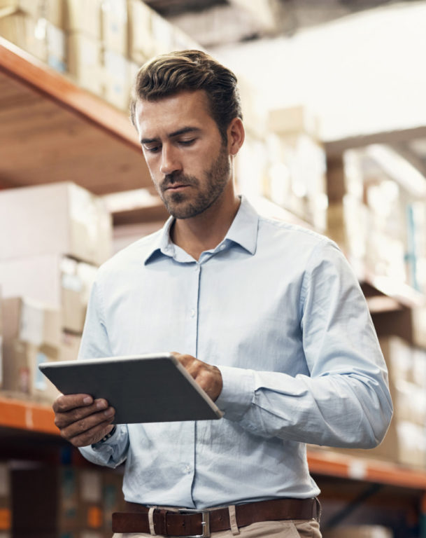 Man using a digital tablet while working in a warehouse