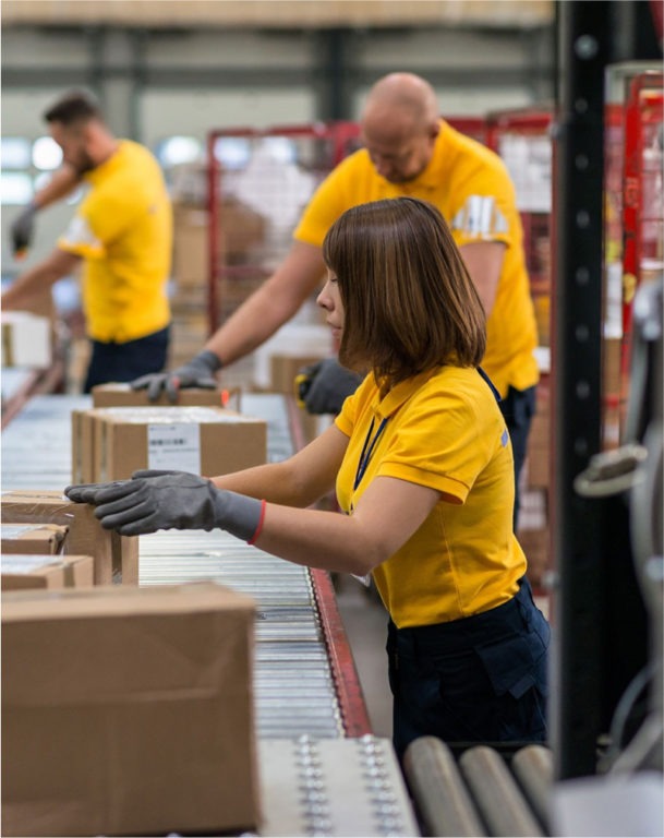 Two men and one woman working in packaging facility