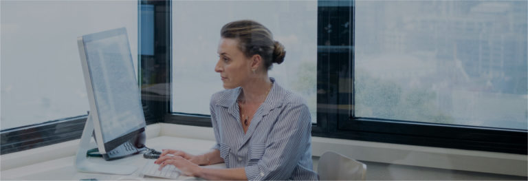 Business woman typing at desktop computer in spacious office