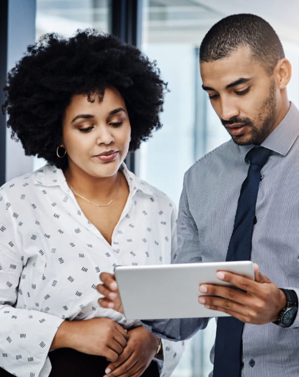 Man holding tablet as female colleague looks on