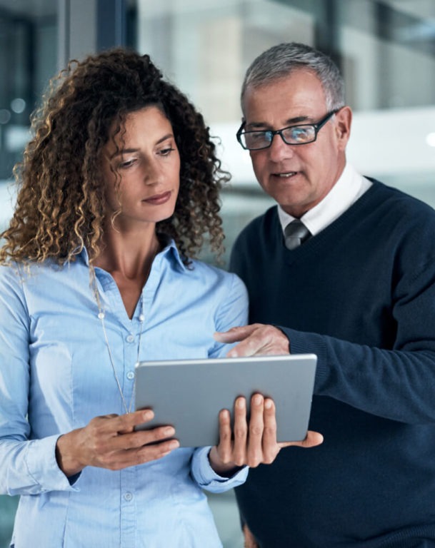 Two coworkers looking at a tablet together in an office